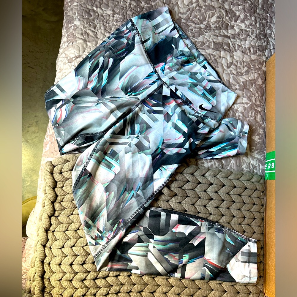 NIKE women’s sports bra and leggings set in multi color geometric design.